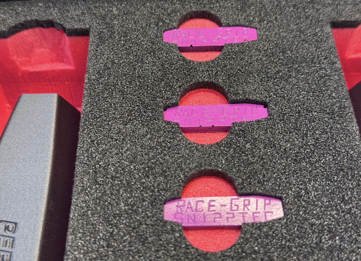Nahaufnahme der violetten Bauteile im Schaumstoff, eines trägt die Aufschrift Race Grip
