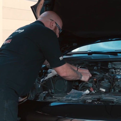 Snippwerk Partner arbeitet am geöffneten Motorraum